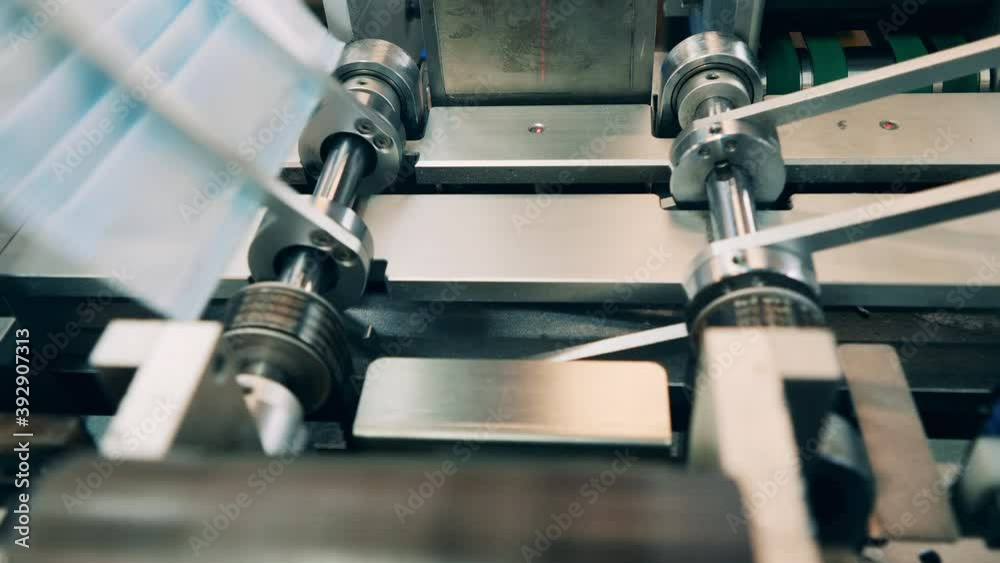 Factory machine is sorting newly-produced face masks Factory machine is sorting newly-produced face masks