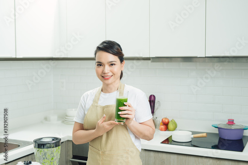 Young Asian Woman Happy Drinking Fresh Green Detox Vegetable Juice.
