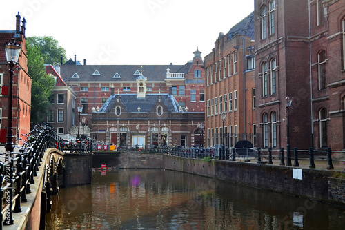 The University of Amsterdam (Dutch: Universiteit van Amsterdam) is a public university located in Amsterdam, Netherlands. Beautiful old building, canal and bicycle parking. photo
