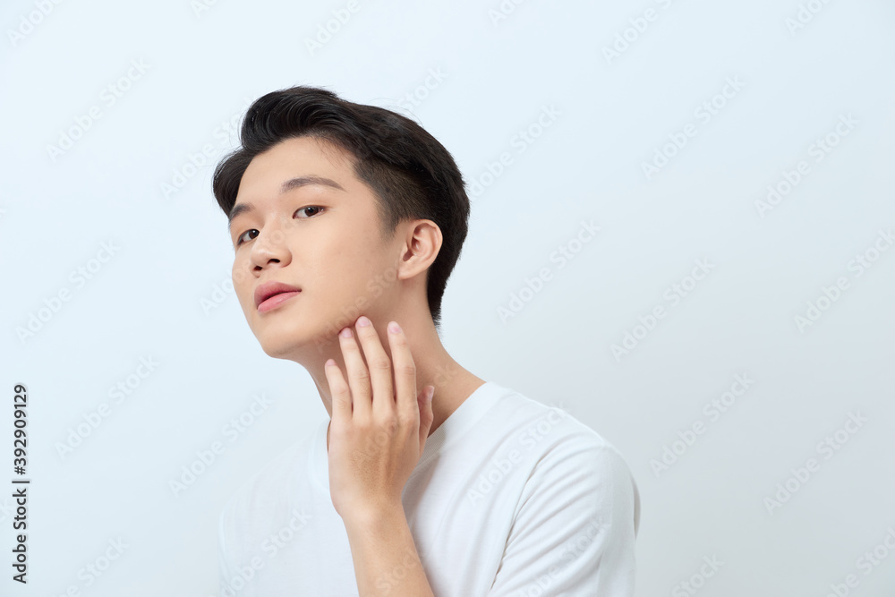 Handsome man. Charming young man keeping hand on chin and smiling while standing against white background Handsome man. Charming young man keeping hand on chin and smiling while standing against white background