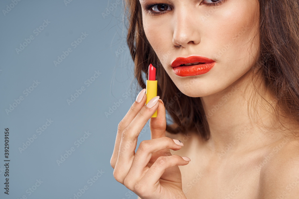 Woman with lipstick on a gray background brunette makeup with eye shadow on the eyelids Woman with lipstick on a gray background brunette makeup with eye shadow on the eyelids