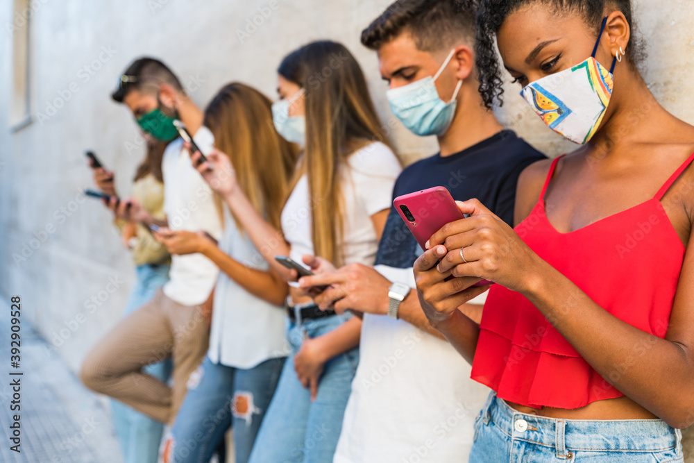 Multiracial people using mobile smart phone with face mask covered
