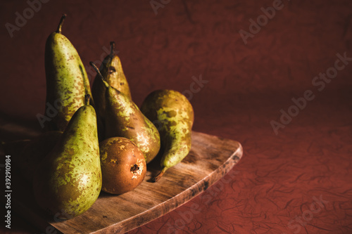 Bunch of organic pears on a rustic  wooden board