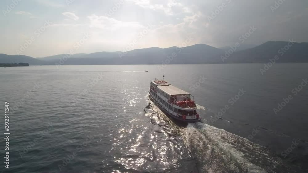 Drone footage in Lake Maggiore of a ferry moving. This footage was shot in northern Italy, Lombardia.