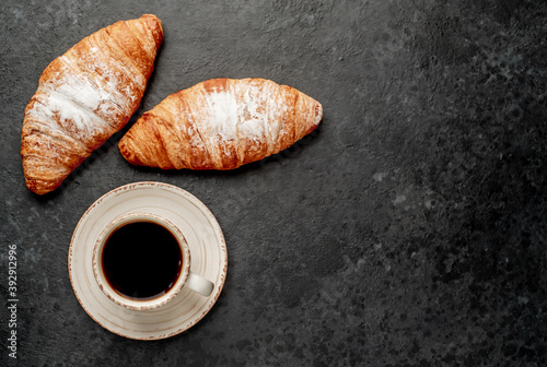coffee and croissants on stone background with copy space