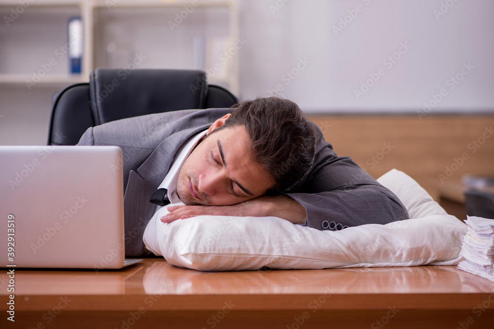 Young male employee sleeping at workplace Young male employee sleeping at workplace