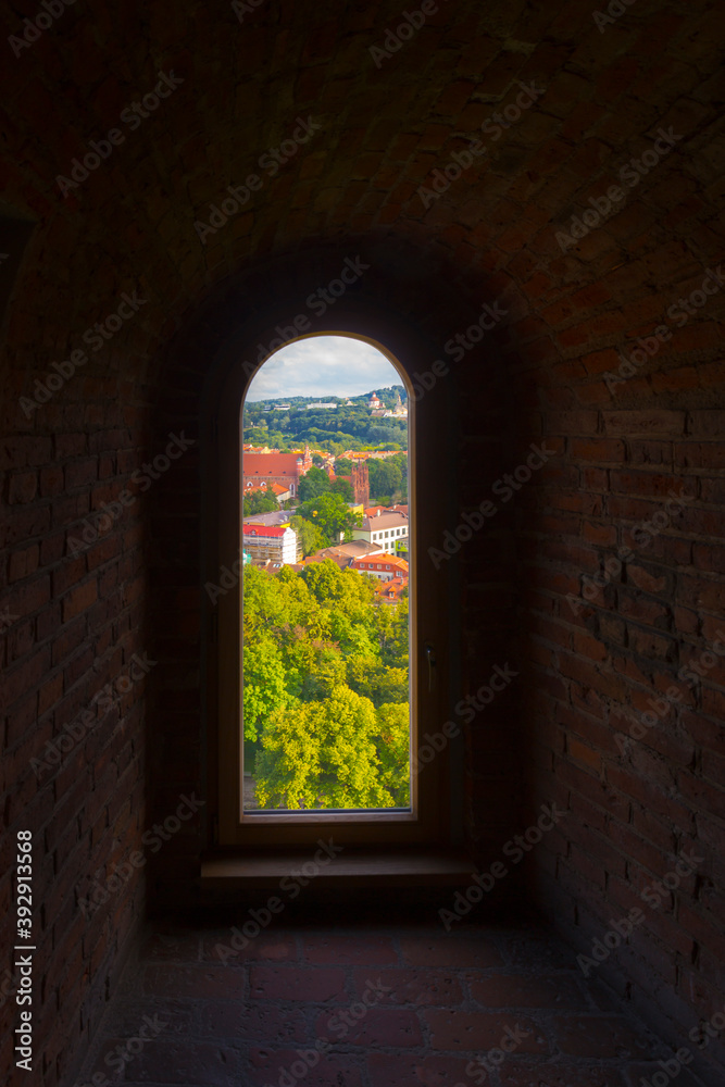 Fototapeta premium Old stone window view on old town of Vilnius.
