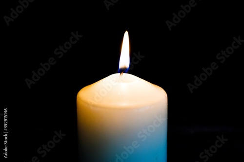 Close-up Candle flame burns on a black background. Greeting card. Texture background.