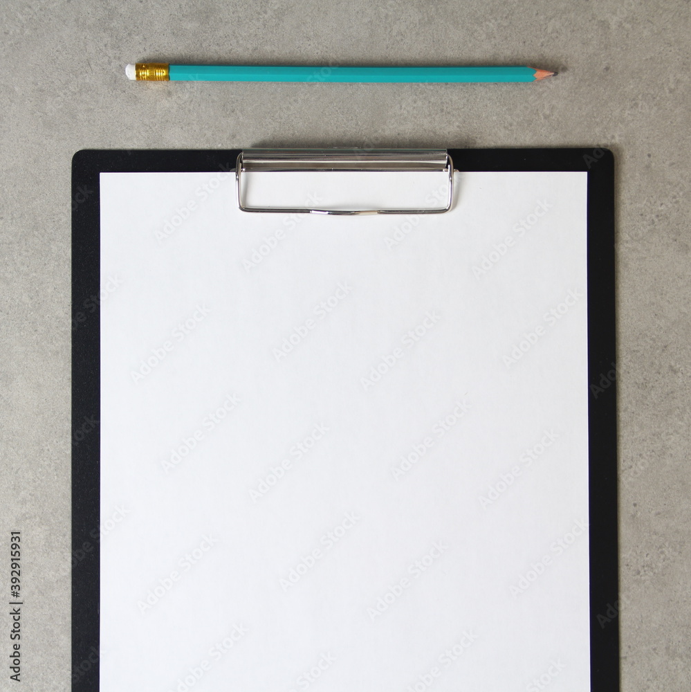 Template of white paper with simple pencil on light grey concrete background in a black tablet with a clip. Concept of new idea, business plan and strategy, empty space for text Template of white paper with simple pencil on light grey concrete background in a black tablet with a clip. Concept of new idea, business plan and strategy, empty space for text