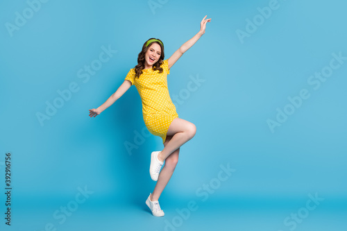 Fototapeta Naklejka Na Ścianę i Meble -  Full body photo of excited girl enjoying raise hands leg isolated over blue color background