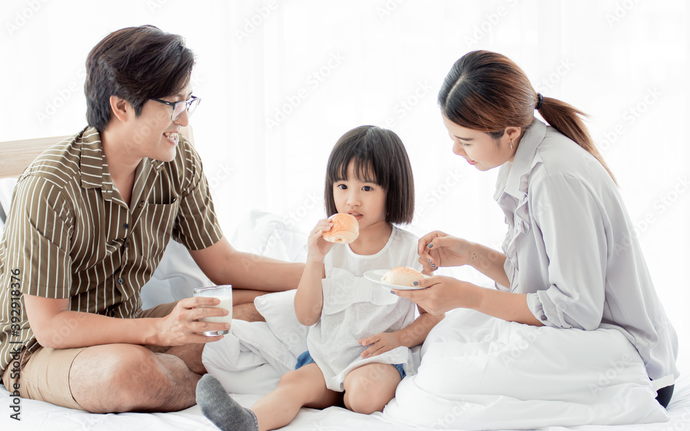 A parents serving breakfast to their little daughter A parents serving breakfast to their little daughter