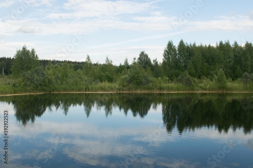 The forest is reflected in the water of the lake