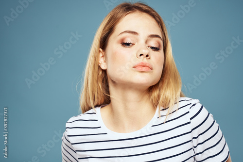 woman wearing striped t-shirt cropped view blue isolated background displeased facial expression © SHOTPRIME STUDIO