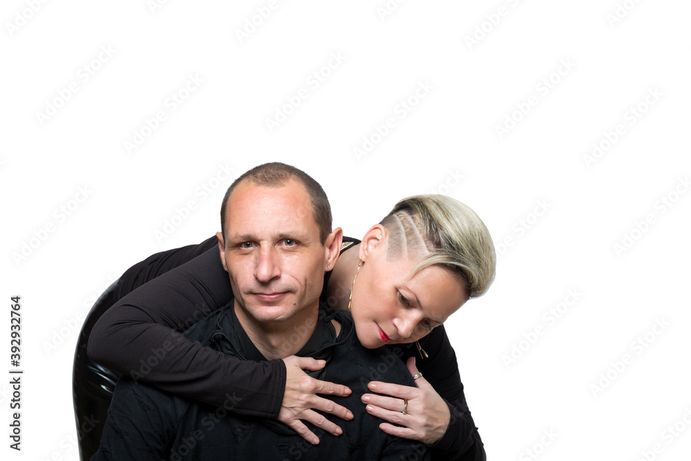 Portrait of a loving young woman embracing man from behind at studio. Beautiful happy couple, family. Stylish haircut. Man with green eyes and Woman on white Background . Studio shot, Copy space. Portrait of a loving young woman embracing man from behind at studio. Beautiful happy couple, family. Stylish haircut. Man with green eyes and Woman on white Background . Studio shot, Copy space.