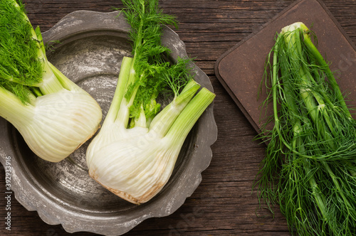 Fresh organic fennel bulbs on wooden background, fragrant herbaceous plant, healthy vegetable concept (Foeniculum vulgare)