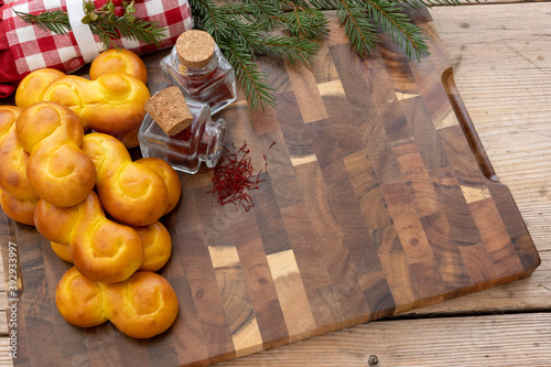 Christmas saffron buns on a beautiful table with saffron spice in small glass jars. Lussekatter. photo