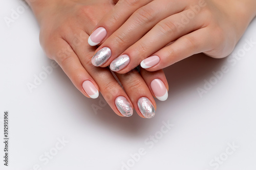 wedding french white manicure with silver decor, matte foil on short oval nails close-up on a white background.