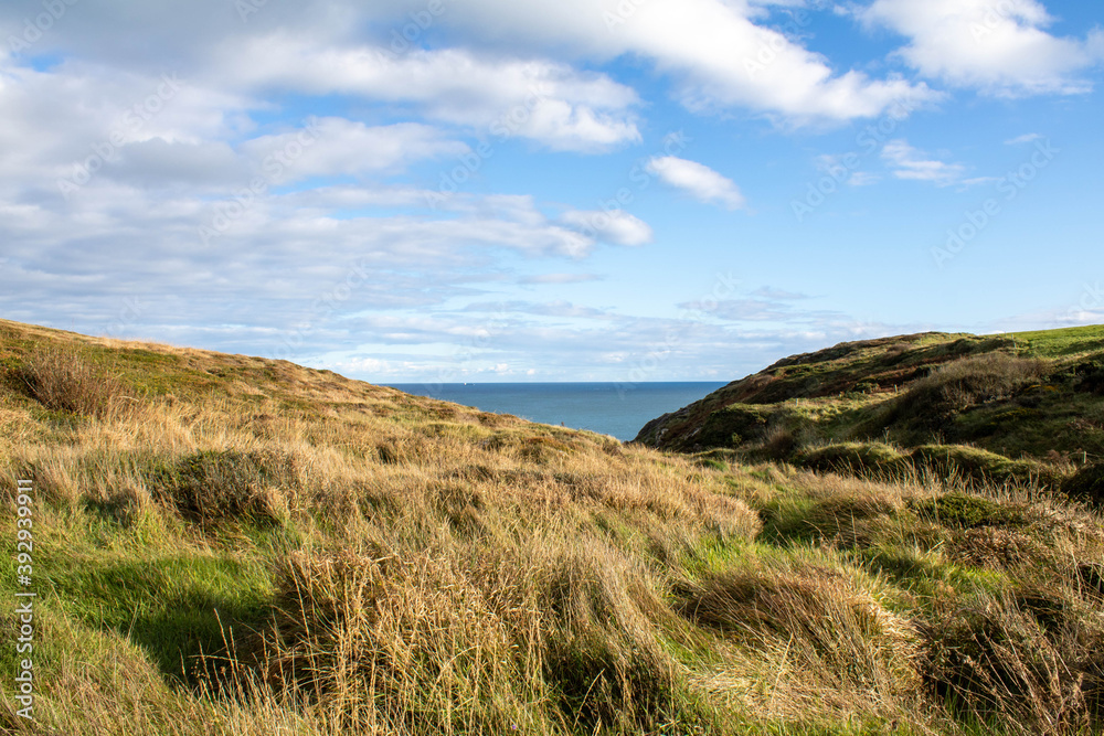 Hiking along the coastal cliffs of West Cork Ireland. Mark and unmarked grass trails and a beautiful view of the Atlantic Ocean.