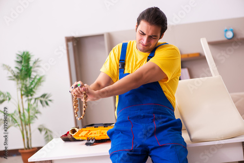 Young male carpenter stealing jewelry at home