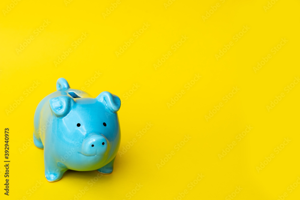 Blue piggy bank smile isolated on yellow background. Finance, saving money concept.