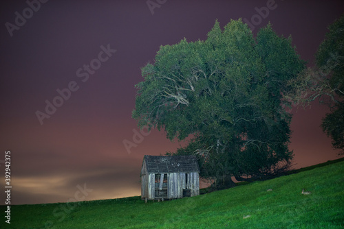 A Lonely Out Building Slowly Crumbling on a Farm photo