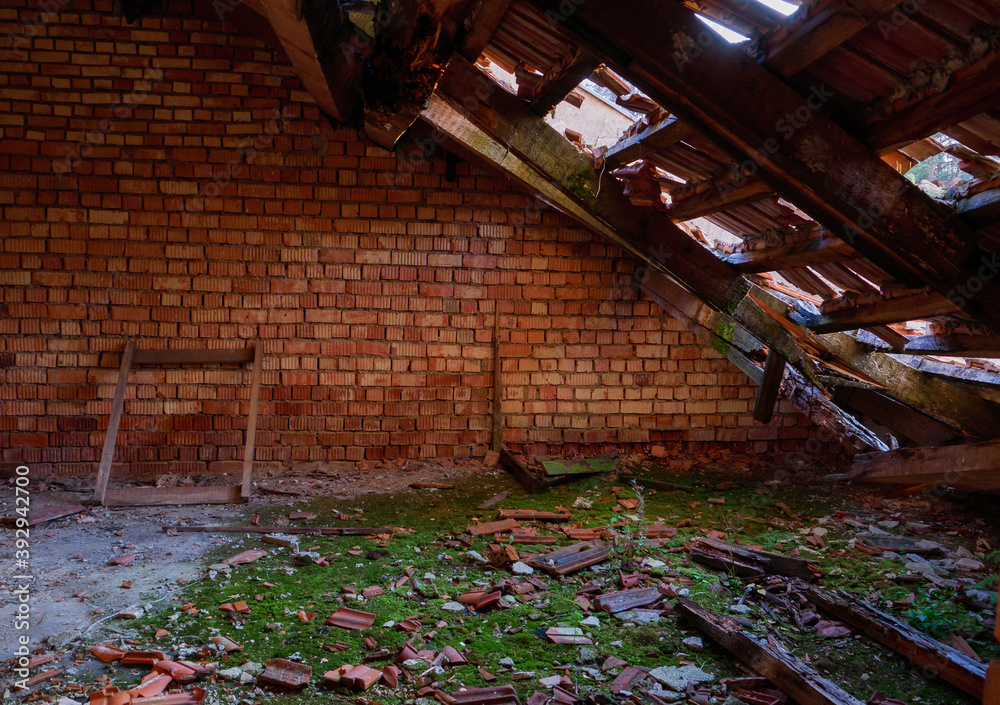 Rotten attic of an abandoned building. Old ruined attic with a brick