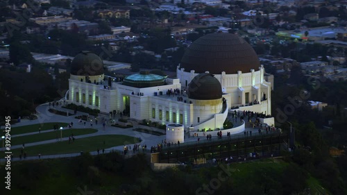 Amazing aerial view of the Griffith Observatory in Mount Hollywood. Crowded entrance lawn and observation deck. Los Angeles, California. Beautiful sky during sunset. Shot on Red Weapon 8K.