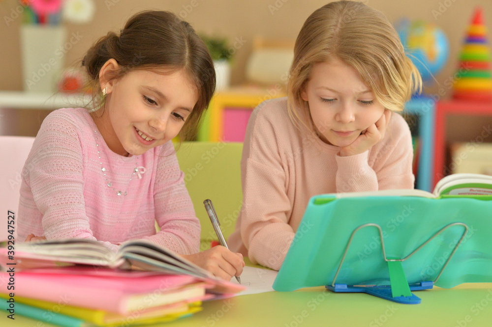 Portrait of two beautiful little girls doping homework Portrait of two beautiful little girls doping homework