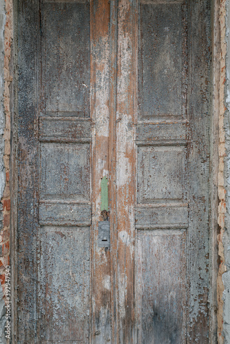 Old shabby, cracked door with sprinkled paint. The door is a hundred years old. © Uladzimir