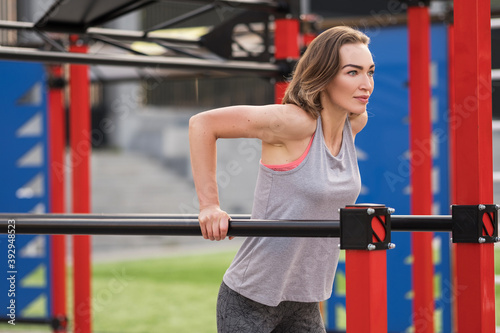 Slim fit adult woman exercise on an outdoor workout training alone. Summer sunset morning portraits in action on a european streets with space for text.