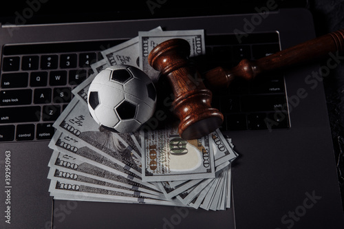 Canvas Soccer ball and wooden gavel on laptop's keyboard