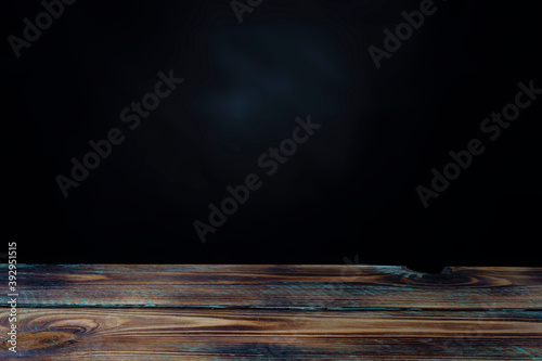 empty wooden table and black wall for product display with space for text or photo