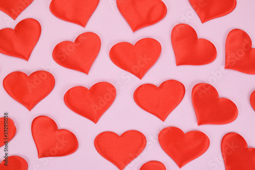 Festive pattern of red decorative hearts on a pink background