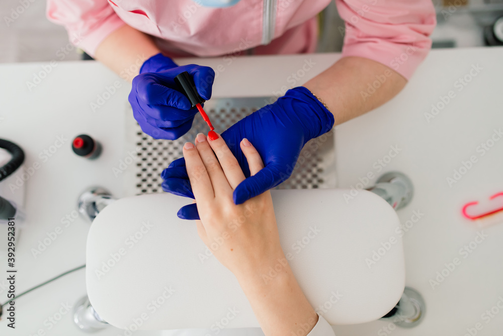 Female manicure master in a beauty salon work with hands of the client