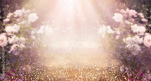 Fototapeta Naklejka Na Ścianę i Meble -  Fantasy pink Roses Flowers bloom and Road leads forward in Fabulous mystical Paradise Garden, mysterious Fairy Tale Summer floral Background with glowing sun Rays, amazing Heaven Nature Landscape