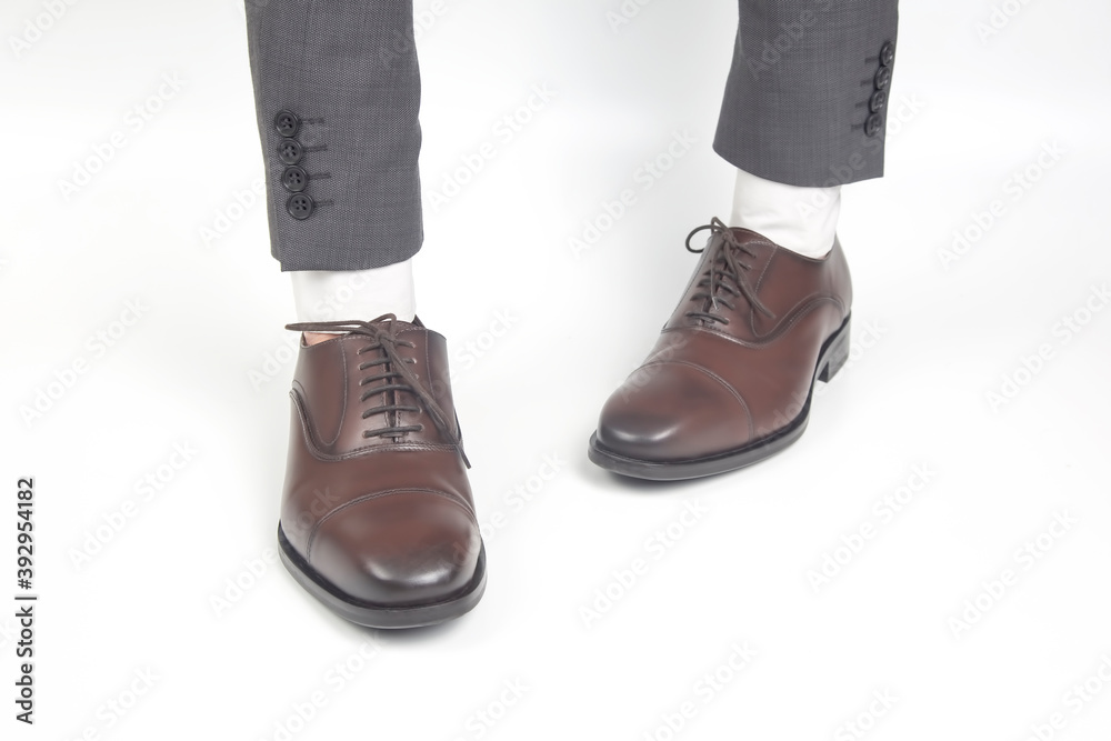 Classic brown leather shoes worn on the hands on a white background