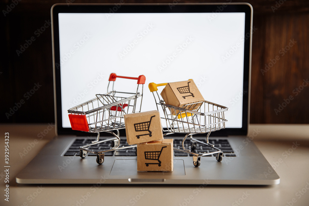 Boxes in a trollies on a laptop keyboard. Online shopping concept.