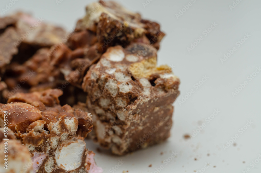 A marvelous mix of sultanas, marshmallows, biscuit pieces, crispy rice and glacé cherries covered in milk chocolate A marvelous mix of sultanas, marshmallows, biscuit pieces, crispy rice and glacé cherries covered in milk chocolate