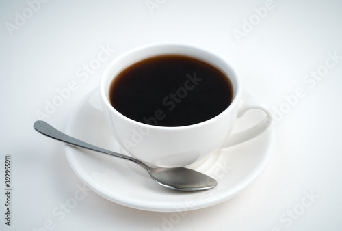A Cup of coffee and a saucer with a spoon on a light background. Side view. Coffee background.