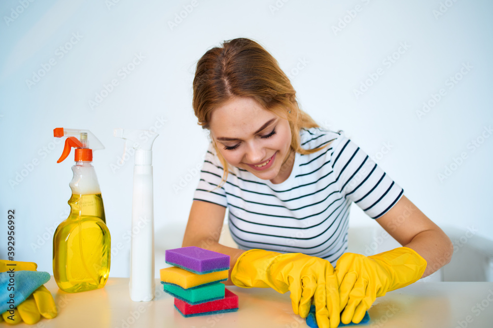 Woman at the table washing supplies housework hygiene service Woman at the table washing supplies housework hygiene service