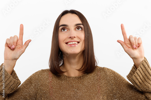 Close-up portrait pretty young woman pointing with two fingers, looking at camera , isolated on white background