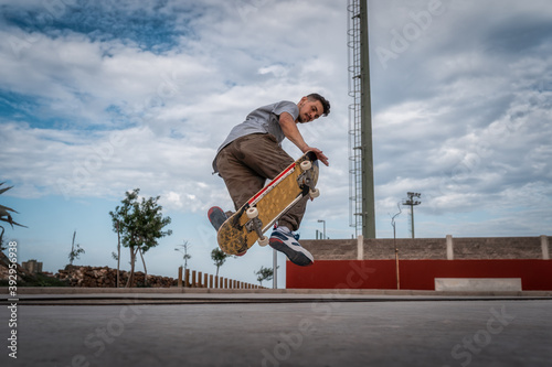hombre joven hace un truco llamado foot plant en un skate park. movimiento 2 photo