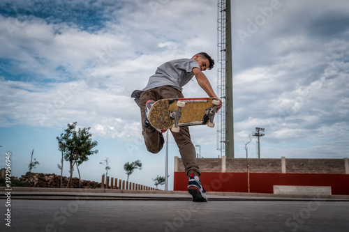 hombre joven hace un truco llamado foot plant en un skate park. movimiento 1 photo