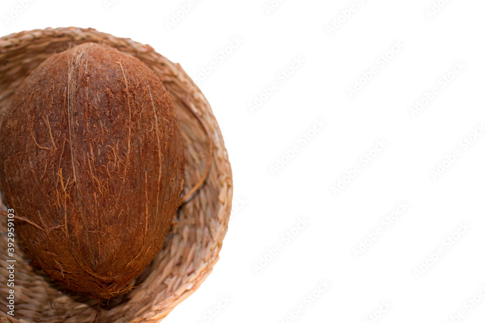 One Coconut In A Wicker Plate In Selective Focus. Isolated Image On A White Background With Copy Space.