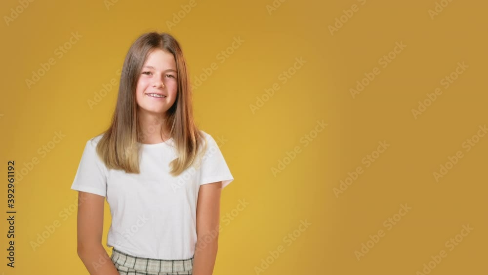 Happy child. Advertisign background. Positive lifestyle. Motivation inspiration. Portrait of satisfied cheerful teen girl in braces white t-shirt smiling isolated on yellow copy space. Happy child. Advertisign background. Positive lifestyle. Motivation inspiration. Portrait of satisfied cheerful teen girl in braces white t-shirt smiling isolated on yellow copy space.