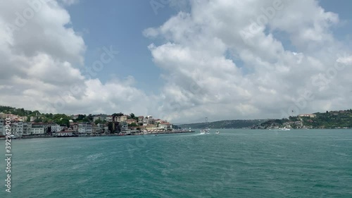 Footage of cruise tour boat passing on Bosphorus by upscale neighborhoods called 