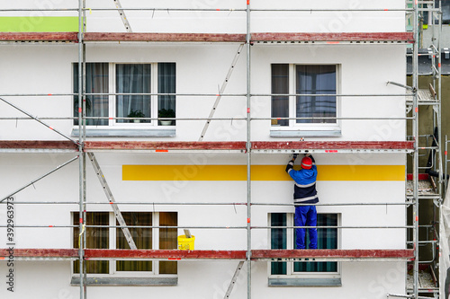 Foto the worker performs finishing works in the renovation of the facade of an apartm