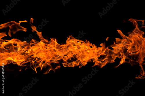 Bright orange red Fire flame against black background with copyspace, abstract texture