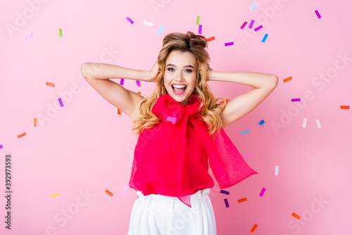 happy woman on pink background with falling confetti
