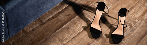 Black high heeled shoes on wooden floor, banner